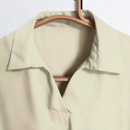 OnenessU short-sleeve basic blouse in a soft yellow-base tone, featuring a minimal collar and recycled polyester.